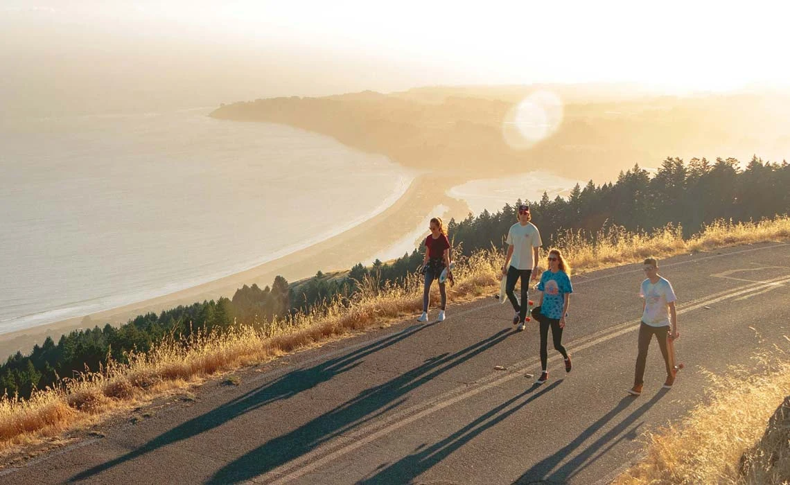 friends walking coastal road