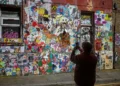 person photographing graffiti wall