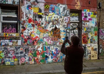 person photographing graffiti wall