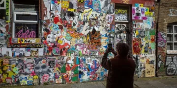 person photographing graffiti wall